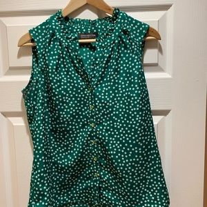 Green sleeveless blouse with white polka dots